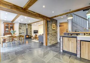 een open keuken en een woonkamer met een tafel en stoelen bij 2 Bed in Machynlleth oc-bow39 in Darowen