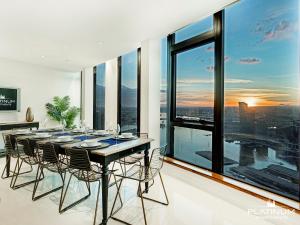 墨爾本的住宿－Platinum Luxury Stays at The Victoria Rooftop Penthouse，一间带桌椅和大窗户的用餐室