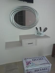 a bathroom with a mirror and a shelf with a box at Zachos in Olympic Beach