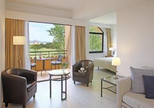 a hotel room with a bed and a living room at La Costa Hotel Golf & Beach Resort in Pals