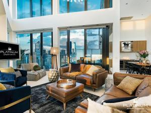 墨爾本的住宿－Platinum Luxury Stays at The Victoria Rooftop Penthouse，一间客厅,配有皮革家具,享有城市美景