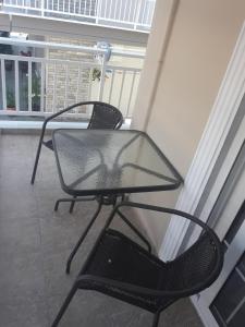 a glass table and a chair on a balcony at Zachos in Olympic Beach