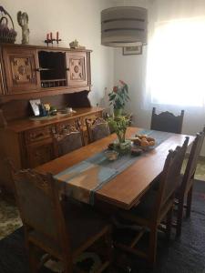 a wooden dining room table with chairs and a television at Apartments Stevo Nikočević in Bar