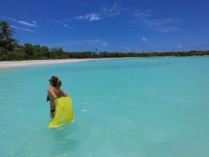 a man on a surfboard in the water at Saona Beach House - Bed and Breakfast in Mano Juan