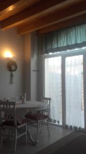 a dining room with a table and a large window at Agriturismo Corte Zuccone in Volta Mantovana