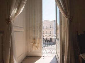 トラーニにあるB&B Imperialeの建物の景色を望むバルコニーへの開放ドア