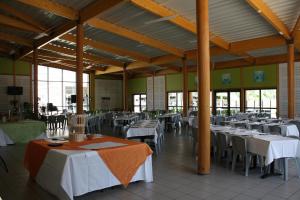 a dining room with white tables and chairs at Village Vacances Passion Le Cezallier in Ardes-sur-Couze