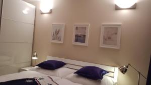 1 dormitorio con 1 cama con 2 almohadas azules en Mimi Apartman, en Balatonalmádi
