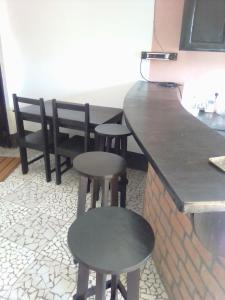 a kitchen with two stools and a counter with a counter at Villa Cassis in Ivato