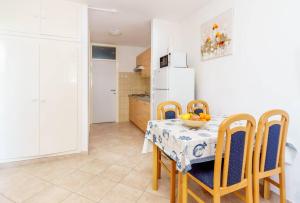 a kitchen with a table and chairs and a white refrigerator at Lumbarda Driftwood in Lumbarda