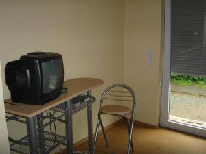 mały telewizor siedzący na stole z krzesłem w obiekcie Gasthof Zum Stausee w mieście Engelskirchen