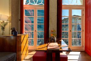 un soggiorno con tavolo e ampie finestre di Flores Lofts a Porto