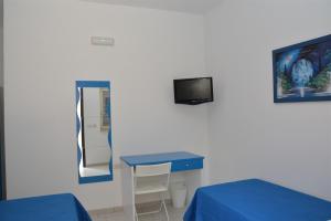 a hospital room with a blue table and a tv at Il Corvino in Diamante
