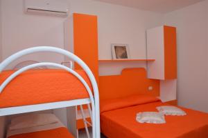 a bedroom with two bunk beds and orange walls at Il Corvino in Diamante