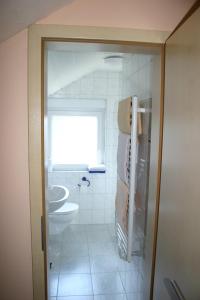 a bathroom with a sink and a toilet and a window at Gasthof Zum Stausee in Engelskirchen