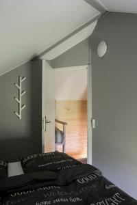 um quarto com uma cama e uma porta para um quarto em Camping Nieuw Romalo em Voorthuizen