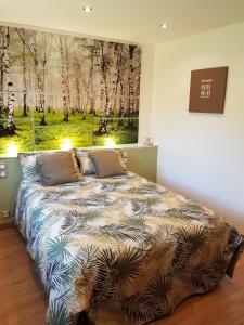 a bedroom with a bed with a painting on the wall at Résidence CoatArmor in Tonquédec