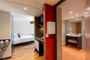 Zimmer mit einem Bad mit einem Bett und einem Spiegel in der Unterkunft Best Western Park Hotel Geneve-Thoiry in Thoiry