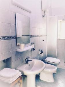 a white bathroom with a sink and a toilet at A casa di Peppe in Naples