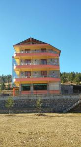 ein hohes Gebäude auf einer Steinmauer in der Unterkunft LURA Hotel in Peshkopi