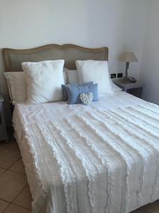 a bed with a white comforter and pillows at Relais Fenicottero Rosa in Porto San Paolo