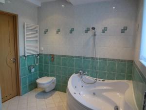 a bathroom with a tub and a toilet and a sink at Apartament przy Bacha in Gdańsk