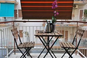 a table and two chairs on a balcony with flowers at Victoria Apartment in Rome