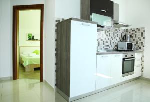 a kitchen with a white refrigerator in a room at Apartments Nemira Exclusive in Omiš