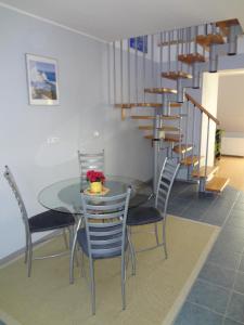 a dining room with a table and chairs and a staircase at Apartament przy Bacha in Gdańsk
