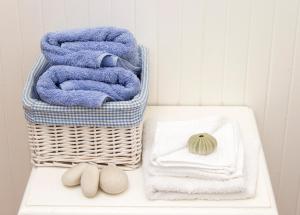 a basket of towels on a table with towels at Albatross Guest House in Simonʼs Town