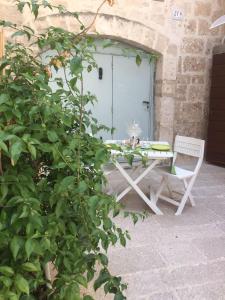 a white table and a chair in front of a door at Casa Aurora 19 in Monopoli
