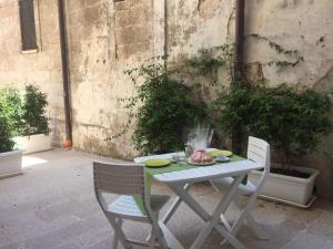 een witte tafel en stoelen met een bord eten erop bij Casa Aurora 19 in Monopoli