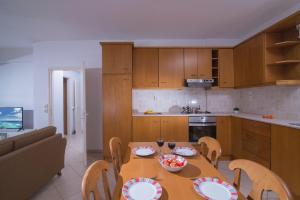 eine Küche mit einem Holztisch und Stühlen sowie ein Esszimmer in der Unterkunft Casa Di Mario in Kokkíni Khánion