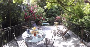 un patio con mesa, sillas y flores en Gîte de la Tour Donjon, en Belcastel