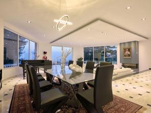 uma sala de jantar com uma mesa de vidro e cadeiras e um piano em Mont Bleu Luxury Villa em Zakynthos