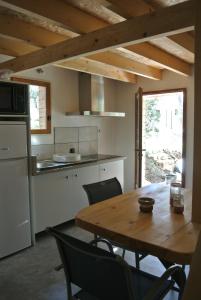 een keuken en eetkamer met een houten tafel bij LA MAISON DES "BOIS" in Lorgues