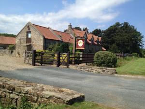 un bâtiment avec une clôture à côté d'une route dans l'établissement Stable Cottage, à Scarborough