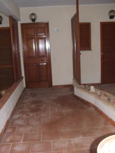 Pokój z drzwiami i podłogą wyłożoną kafelkami w obiekcie Una Finestra sul Mare w mieście Calasetta