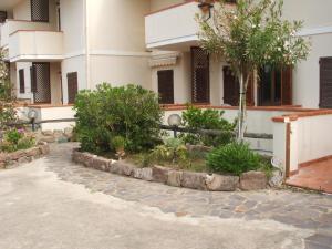 a building with a courtyard with trees and bushes at Una Finestra sul Mare in Calasetta