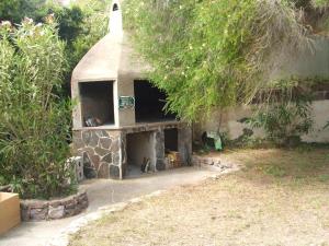 einen Steinkamin in einem Hof neben einem Gebäude in der Unterkunft Una Finestra sul Mare in Calasetta