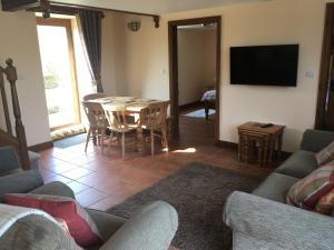 un salon avec une table et une télévision dans l'établissement Stable Cottage, à Scarborough