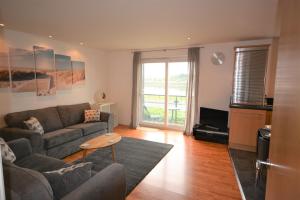 een woonkamer met een bank en een tafel bij Coastal Apartments - Wales in Swansea