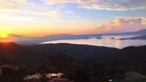 a view of a sunset over a body of water at HappyNest 1857 @ Cityland Tagaytay in Tagaytay