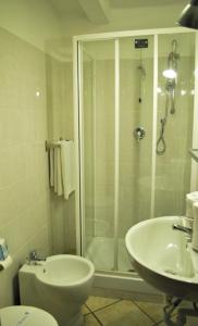 e bagno con doccia, servizi igienici e lavandino. di Hotel Acquario a Genova