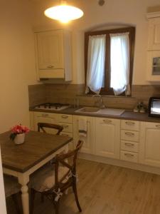 uma cozinha com uma mesa e cadeiras e um lavatório em Agriturismo Terrarossa em Pistoia