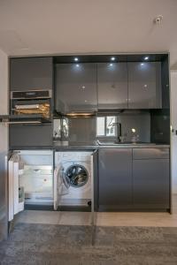 uma cozinha com uma máquina de lavar roupa e uma máquina de lavar roupa em Grafton Street Studios by City Break Apartments em Dublin
