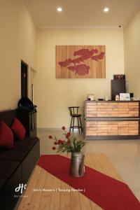 a living room with a couch and a wooden dresser at dric's House in Tanjungpandan