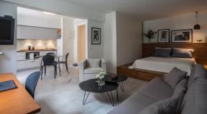 ein Wohnzimmer mit einem Sofa und einem Bett sowie eine Küche in der Unterkunft BRAND NEW apartment below the ACROPOLIS in Athen