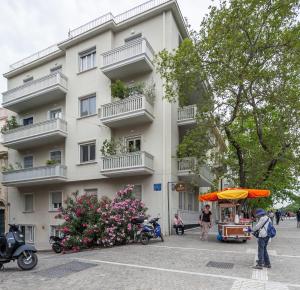 Ein weißes Gebäude mit einem Essenswagen davor. in der Unterkunft BRAND NEW apartment below the ACROPOLIS in Athen