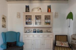 a hutch and a chair in a room at Ergina Summer Resort in Antiparos